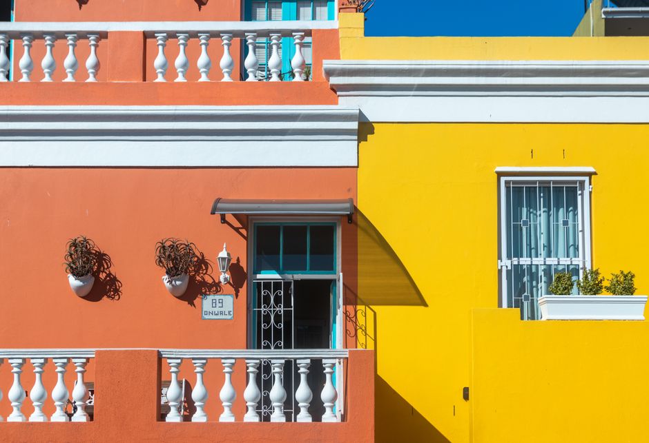 Orange and yellow painted house walls in bright daylight.